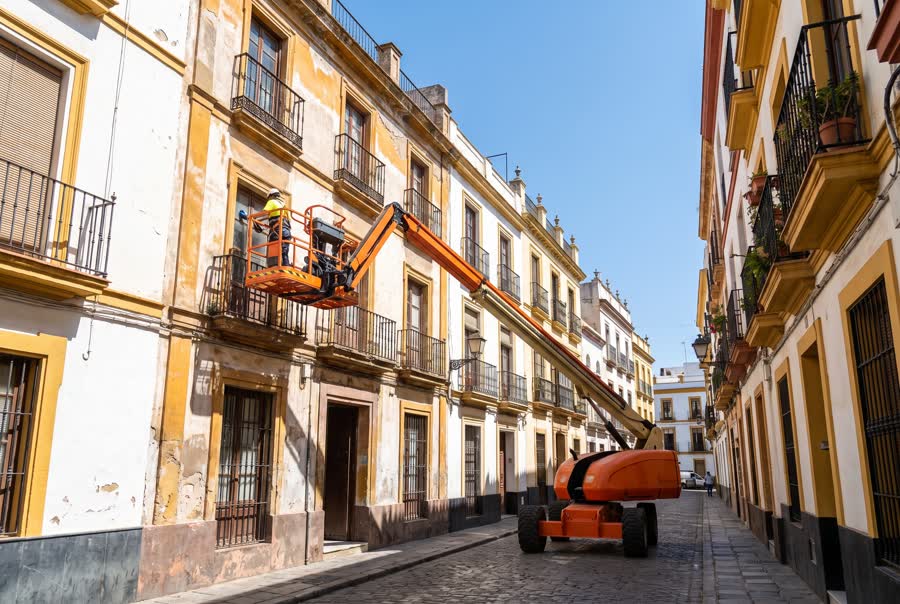 Plataforma elevadora articulada trabajando en la fachada de un edificio